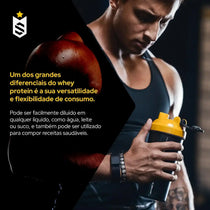 Homem musculoso segurando coqueteleira de whey protein, foco em braço forte, fundo de academia.